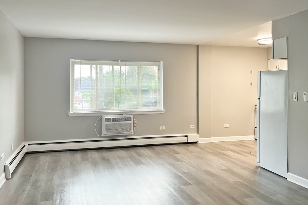 A room with a window and a fan on the floor.