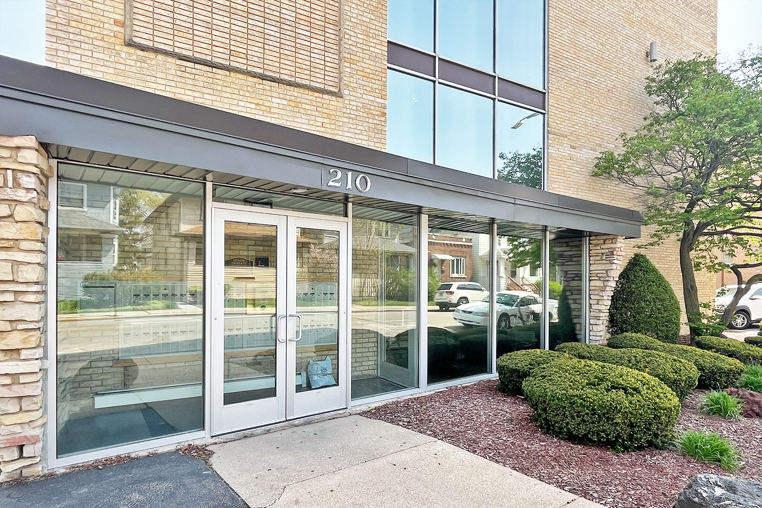 The image shows the front of a building with the number 210 on it.