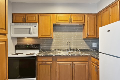A kitchen with wooden cabinets and a white refrigerator.
