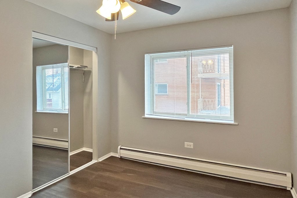 A room with a window and a ceiling fan.