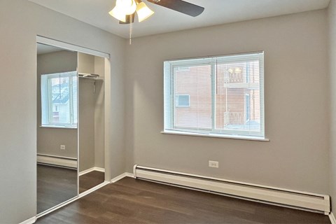 A room with a window and a ceiling fan.