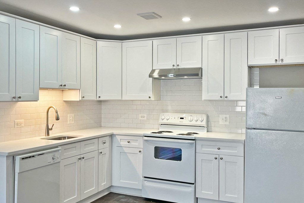 A kitchen with white appliances and cabinets.