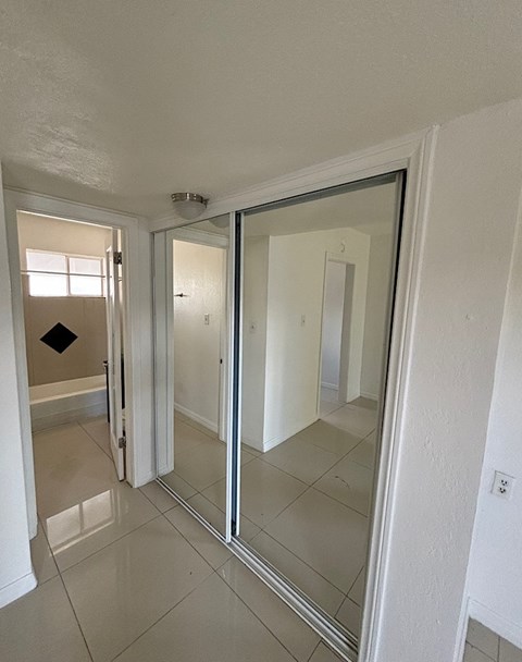 A white bathroom with a glass door and a mirror.