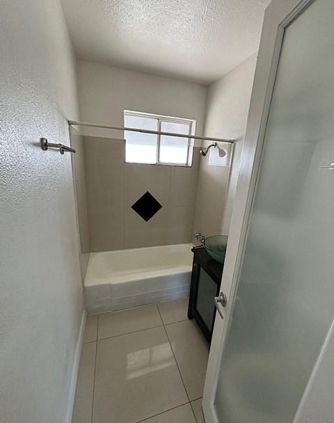 A small bathroom with a tub and a window.