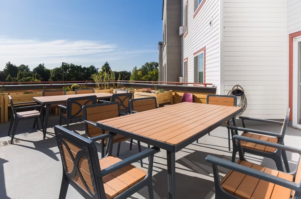 A wooden table and chairs are set up on a patio.