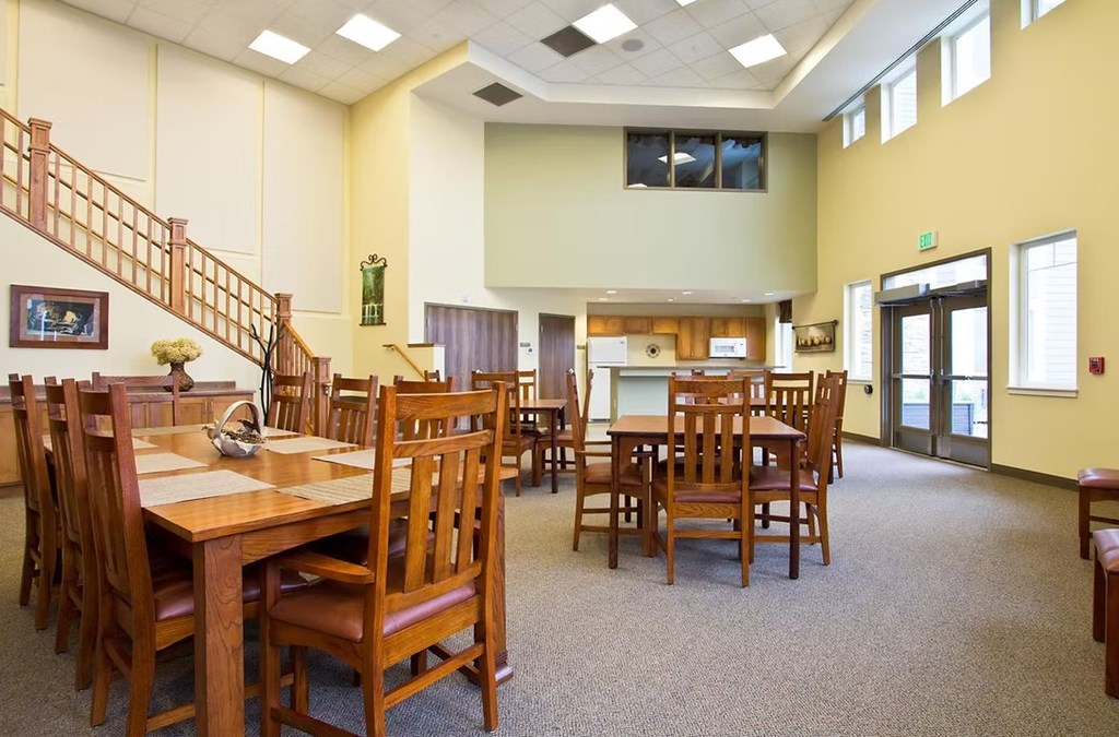 A room with a staircase and tables.
