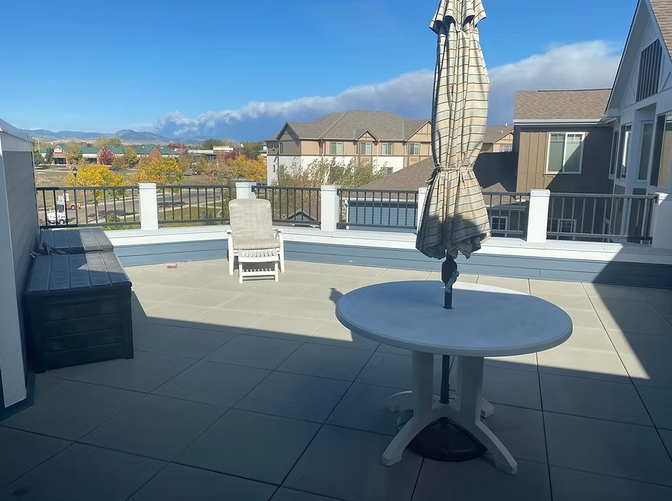 A patio with a table and an umbrella.