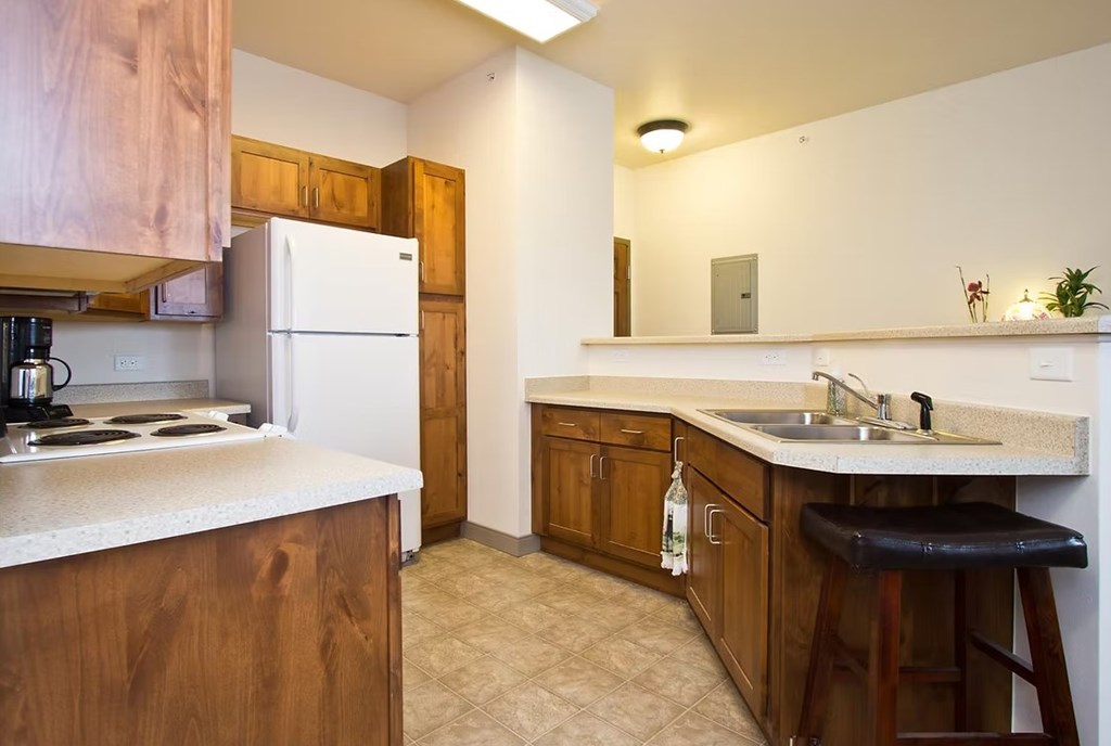 A kitchen with wooden cabinets and a white fridge.