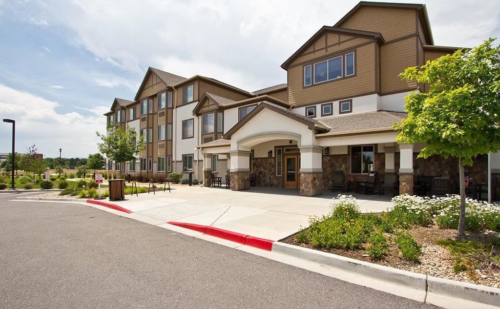 A large building with a parking lot in front.
