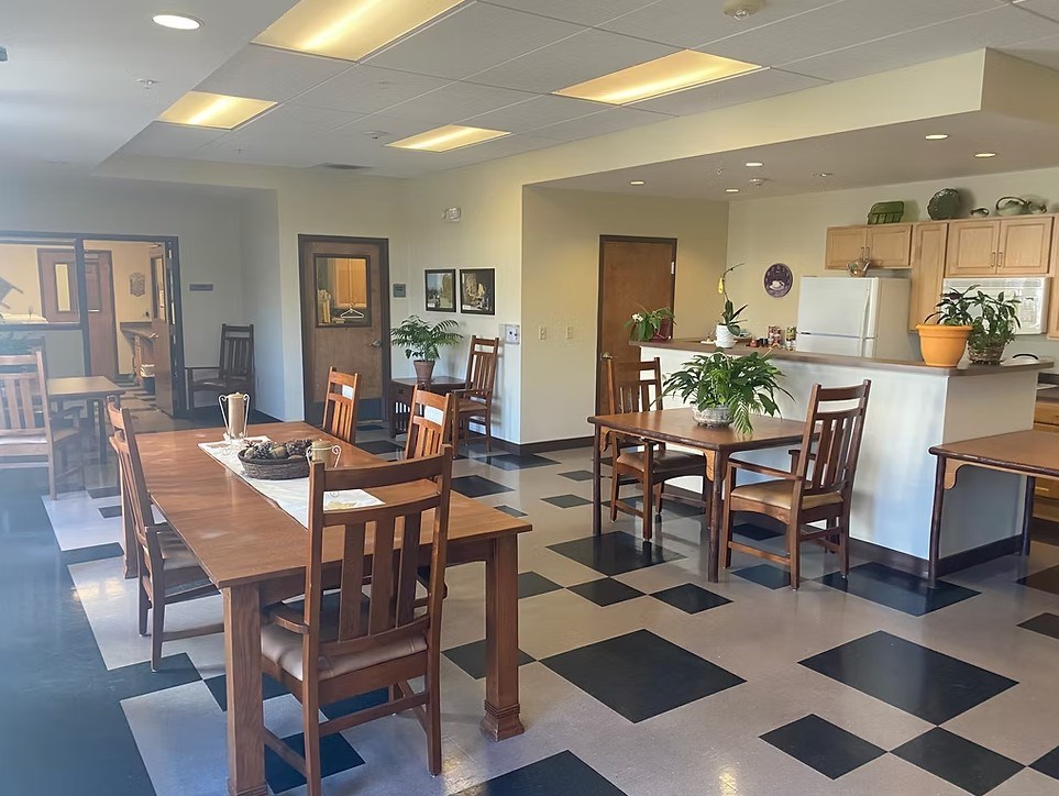 A black and white checkered floor in a room with wooden chairs and tables.