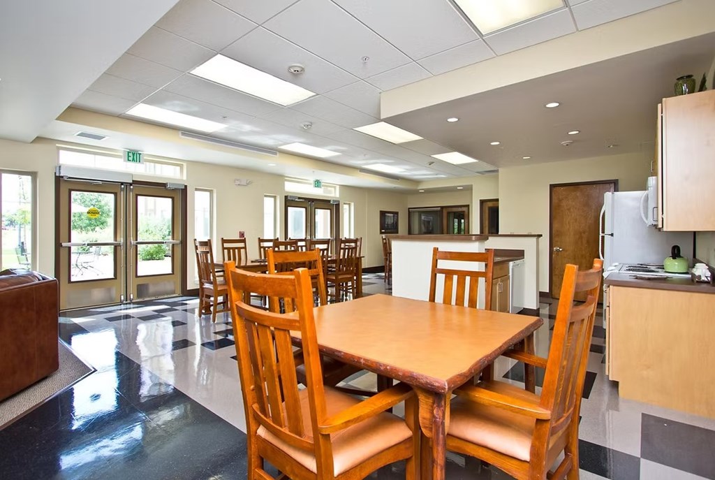 A dining room with a table and chairs.