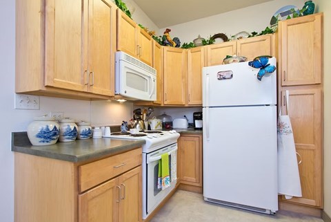 A kitchen with wooden cabinets and a white refrigerator.