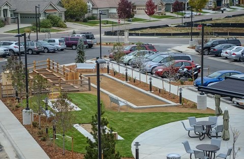 A parking lot with cars and a playground.