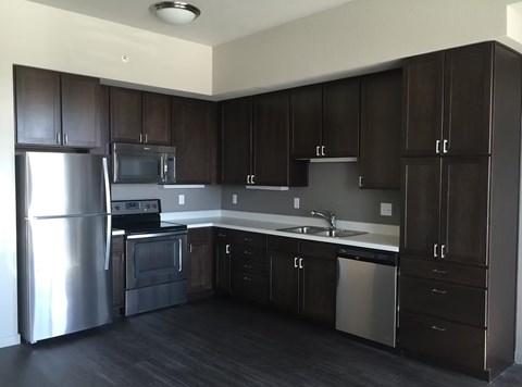 A kitchen with dark brown cabinets and stainless steel appliances.