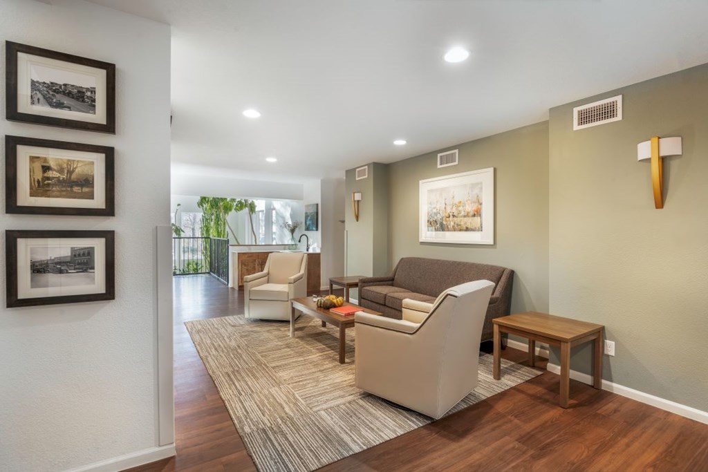 A living room with a couch, chair, and pictures on the wall.