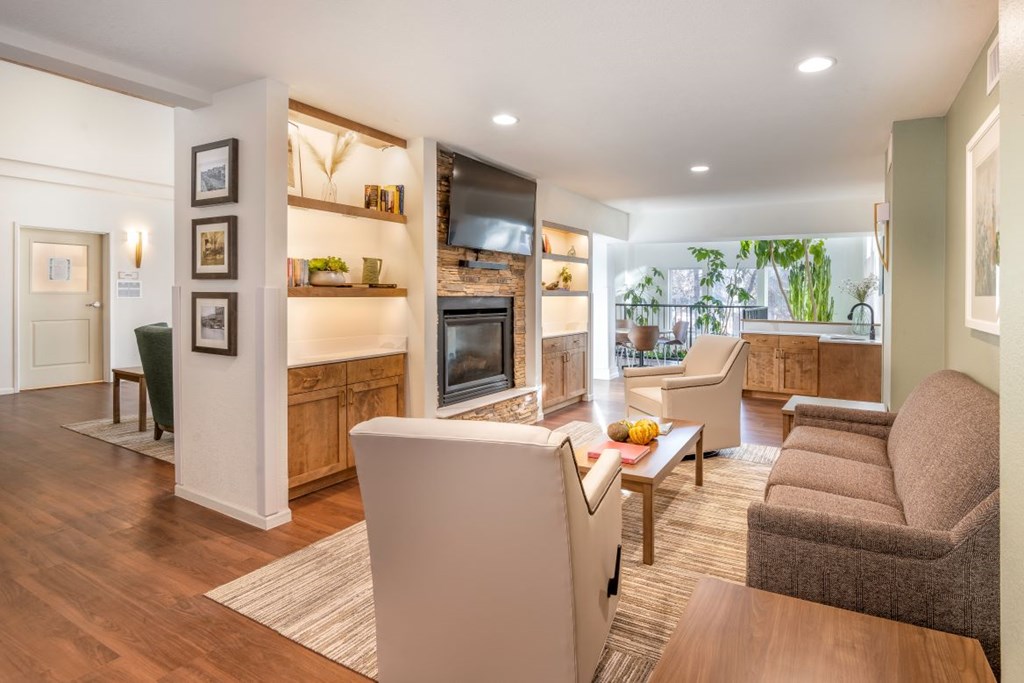 A modern living room with a grey sofa and a white refrigerator.
