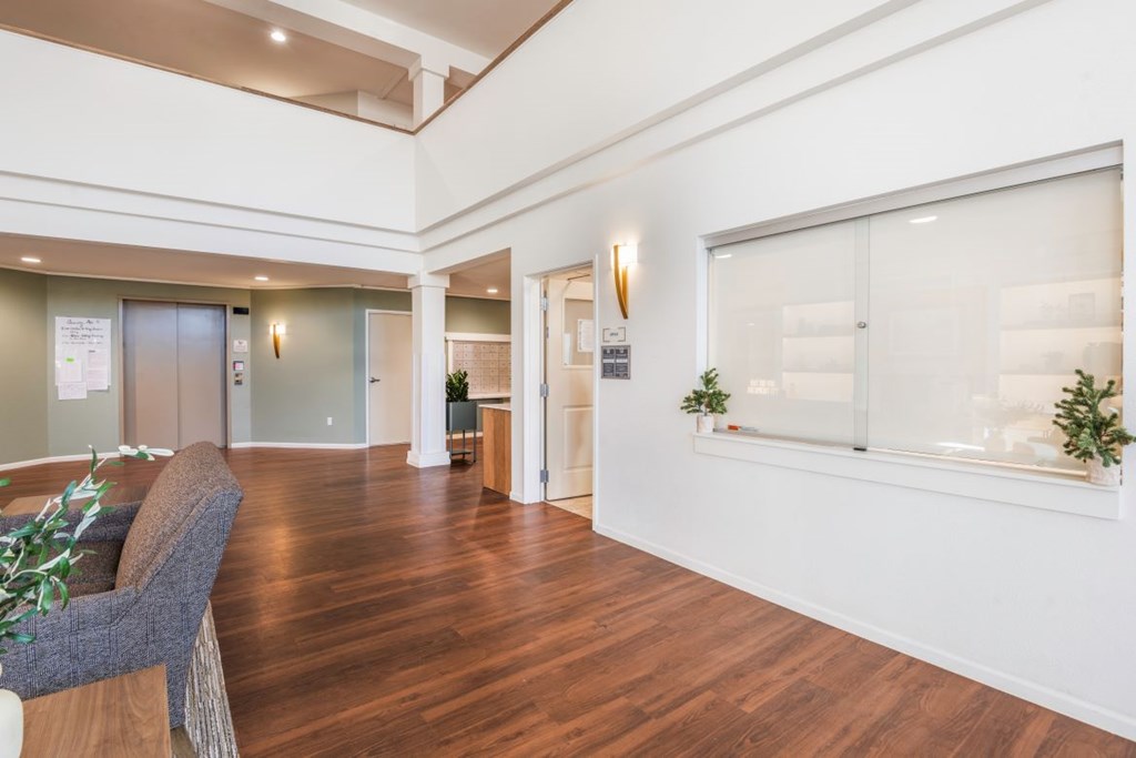 A living room with a grey sofa and a wooden floor.