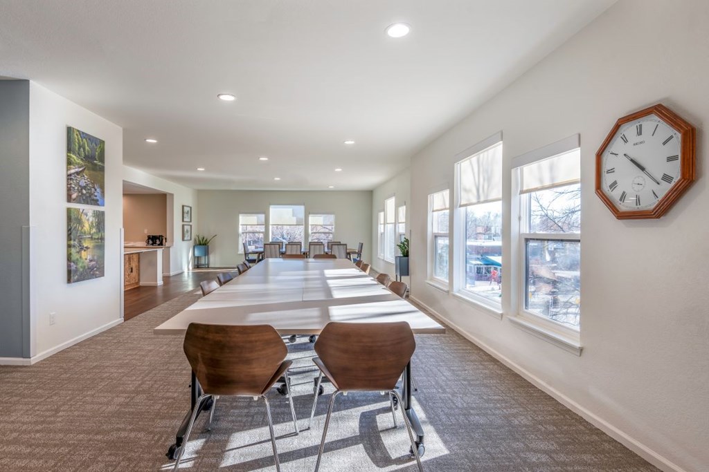 A conference room with a long table and chairs.