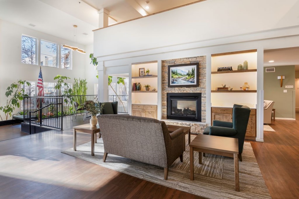 A living room with a fireplace and a painting of a road.