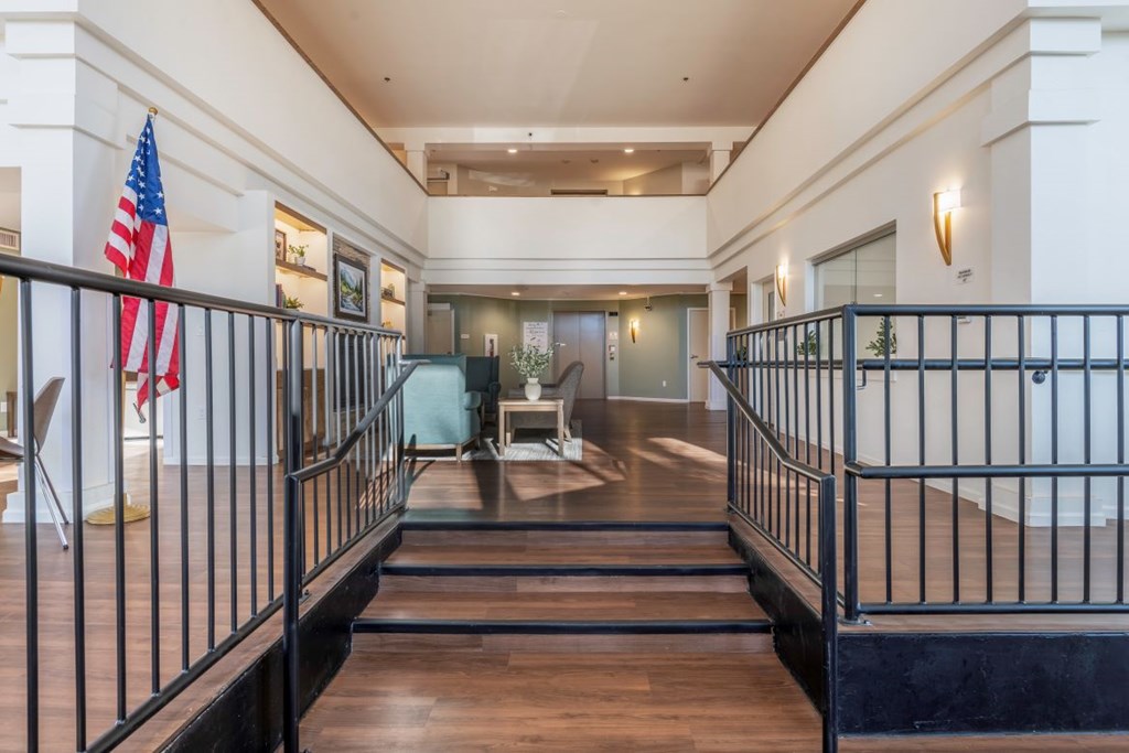 A large foyer with a staircase and a flag.