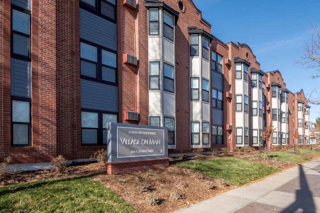A brick building with a sign that says Village on Main.