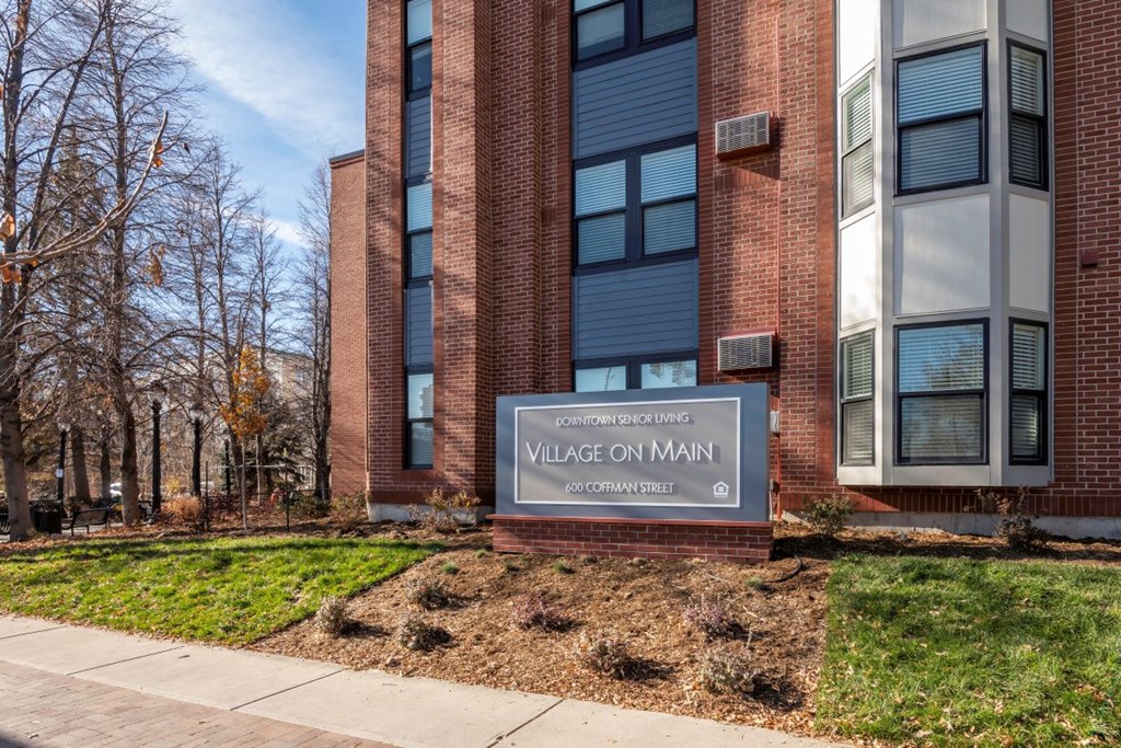 A sign in front of a building that says Village on Main.