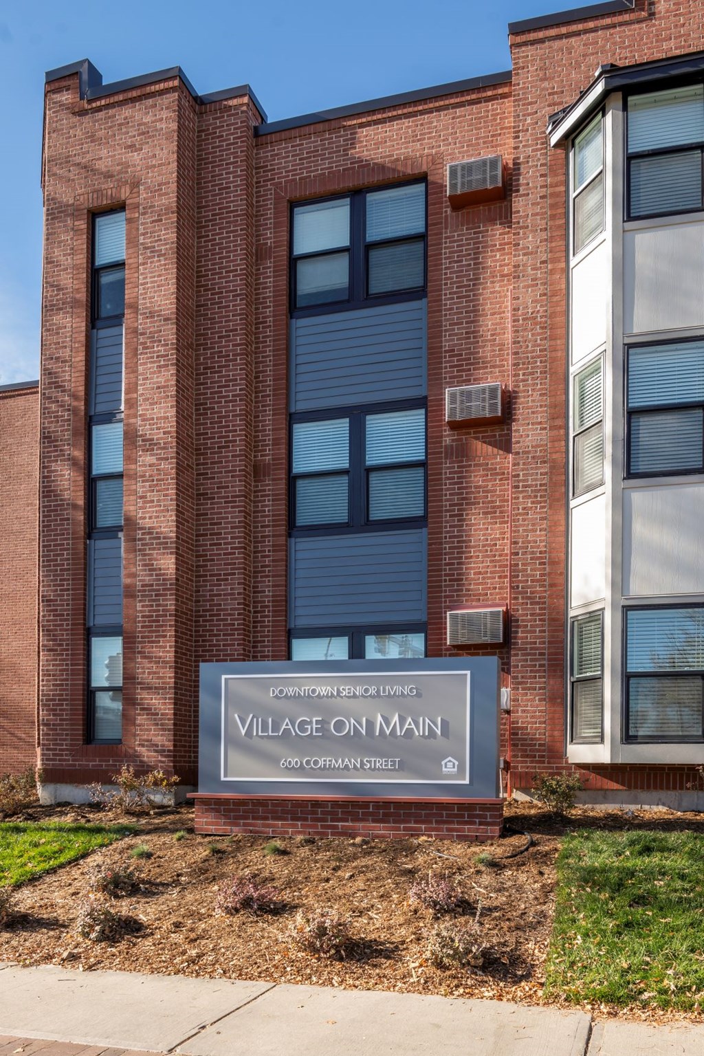 A brick building with a sign that says Village on Main.