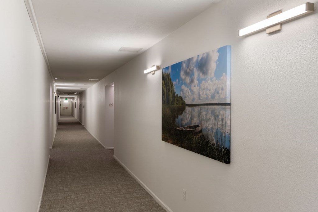 A long hallway with a painting on the wall.