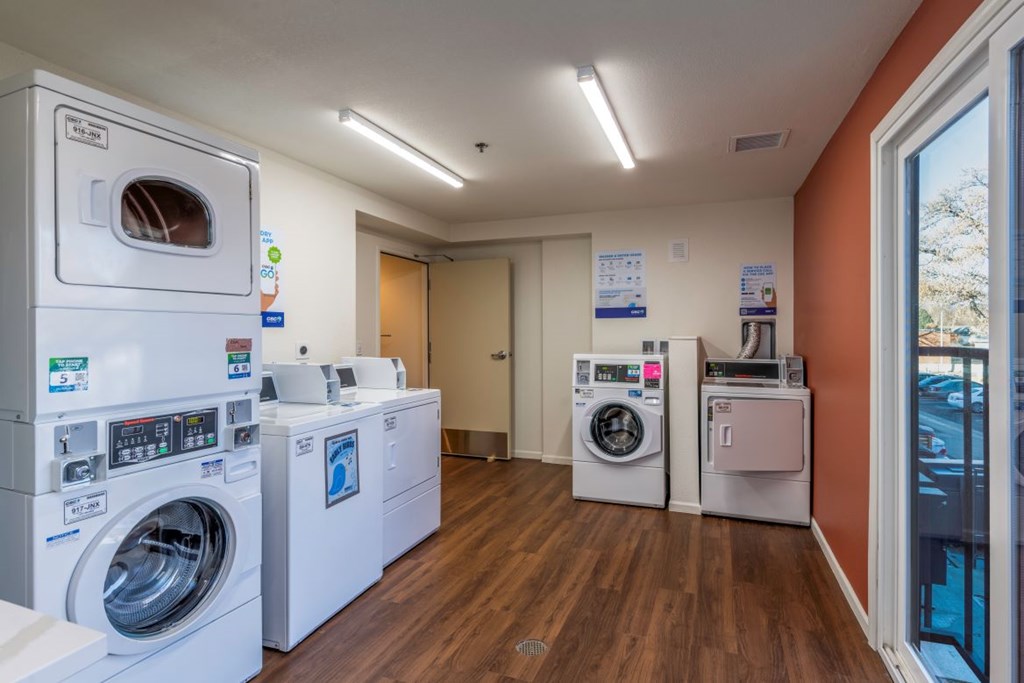 A laundromat with a row of washers and dryers.