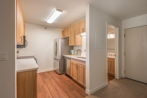 A kitchen with wooden cabinets and a refrigerator.