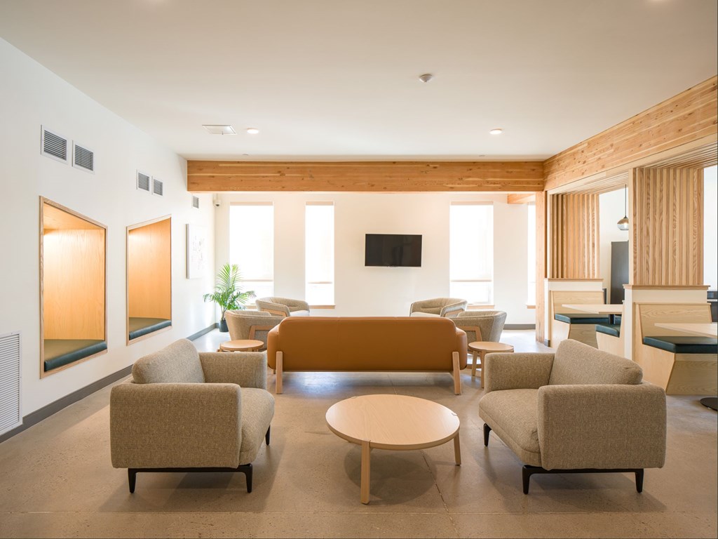 A living room with a couch, chairs, and a television.