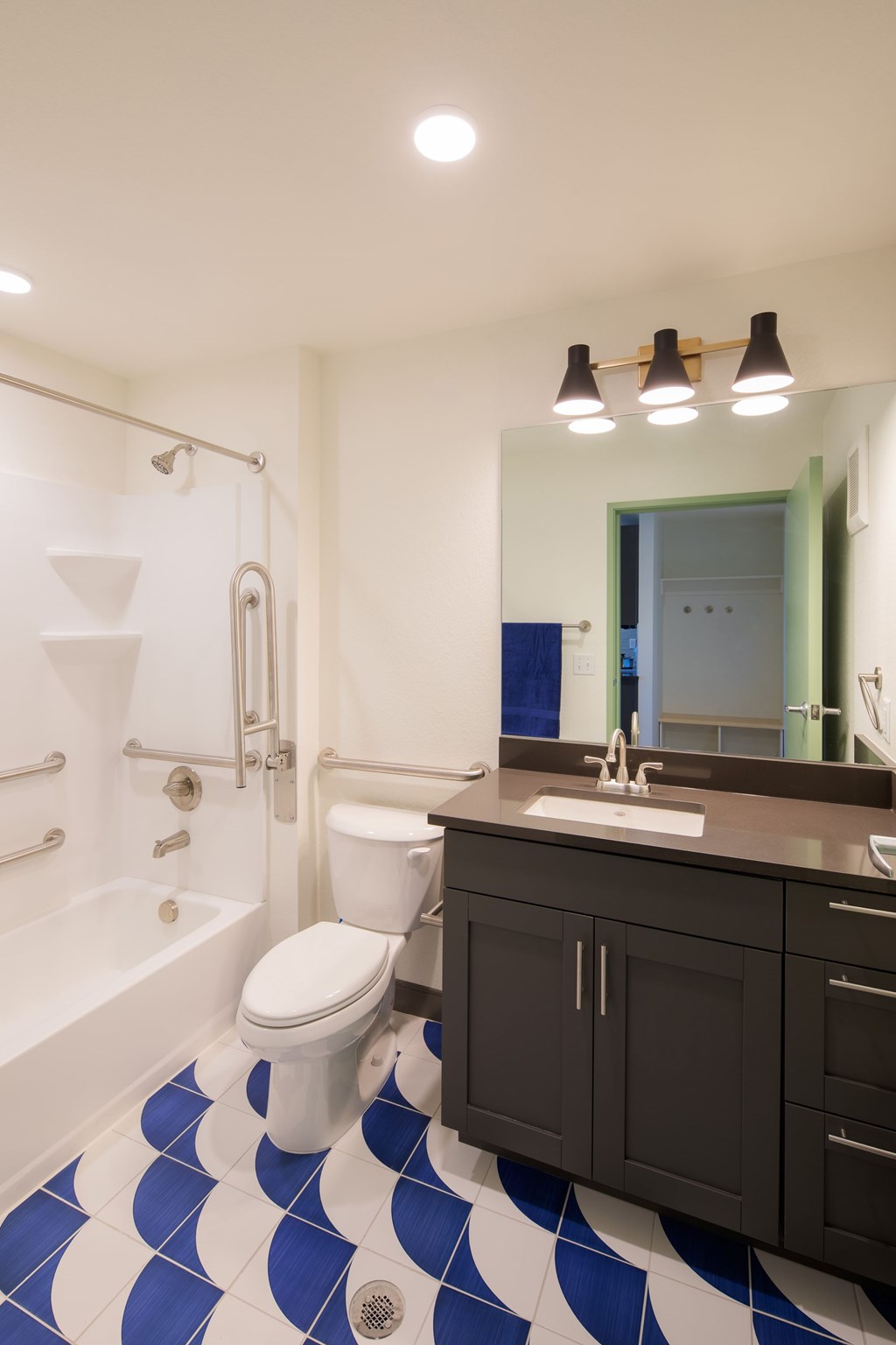 A bathroom with a toilet, sink, and a blue and white tiled floor.