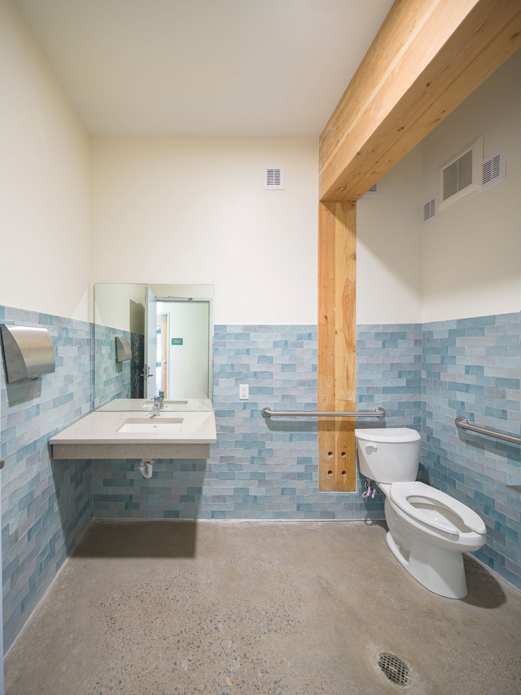A bathroom with a toilet, sink, and mirror.