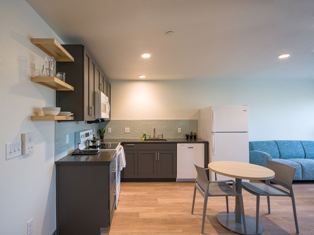 A modern kitchen with a dining table and chairs.