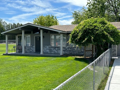 A house with a grey roof and a fence.