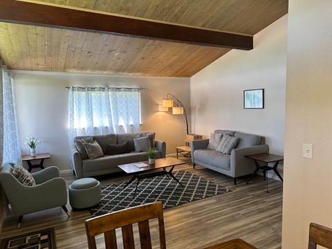A living room with a grey couch and a wooden table.