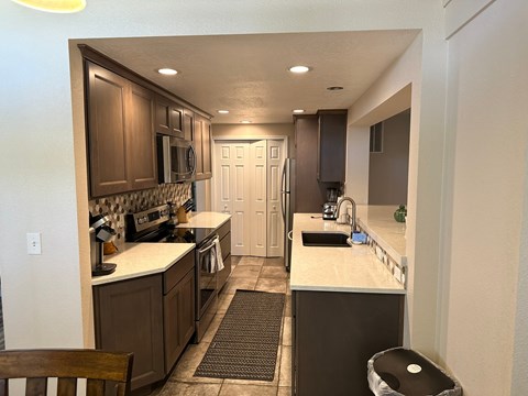 A kitchen with brown cabinets and a white countertop.