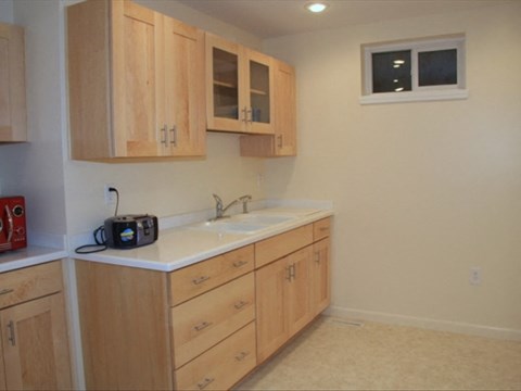 A small kitchen with wooden cabinets and a white counter.