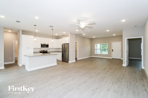 A spacious kitchen with a bar area and a refrigerator.
