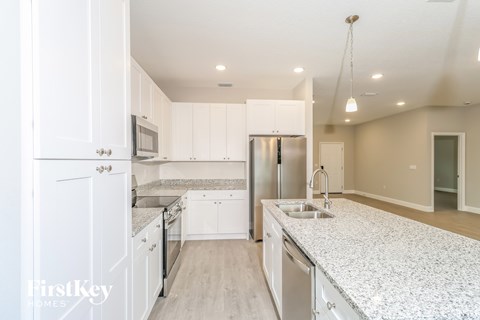 A kitchen with white cabinets and granite countertops.