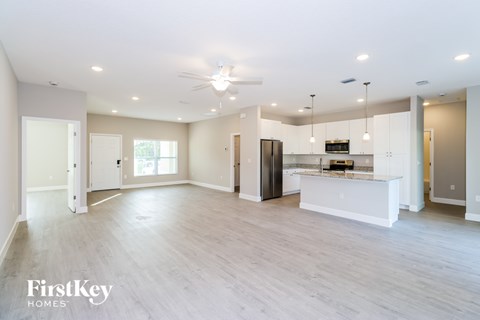 A spacious kitchen with a bar area and a refrigerator.