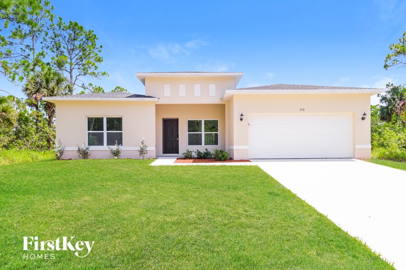 A white house with a black door and windows is for sale by FirstKey Homes.