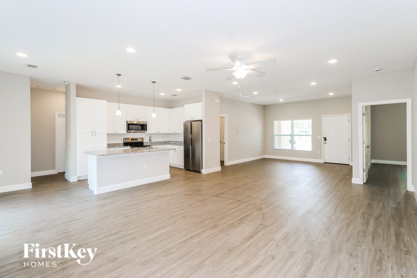 A spacious kitchen with a refrigerator, microwave, and oven.