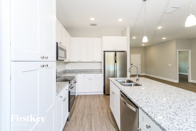 A kitchen with white cabinets and a granite countertop.