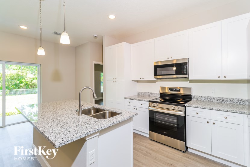 A kitchen with a granite countertop and white cabinets.