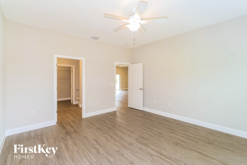 A spacious room with a ceiling fan and wooden flooring.