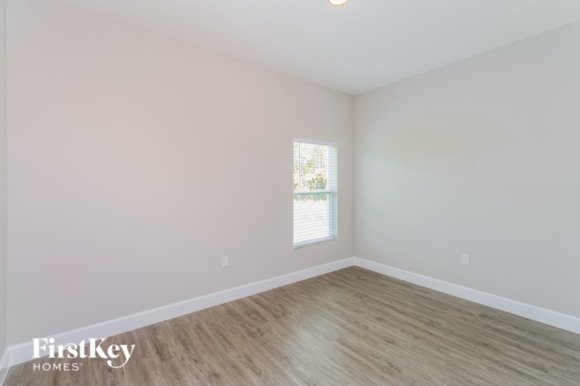 A room with wooden flooring and a window letting in light.