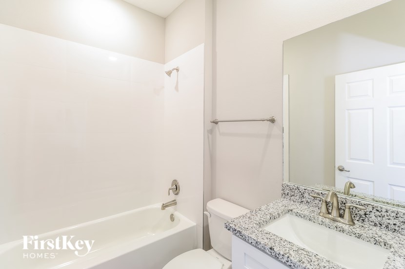 A white bathroom with a tub, toilet, and sink.