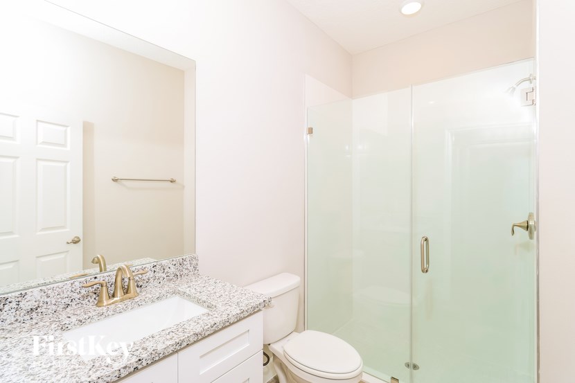 A white bathroom with a sink, toilet and shower.