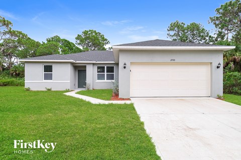 A two-story house with a garage is for sale.